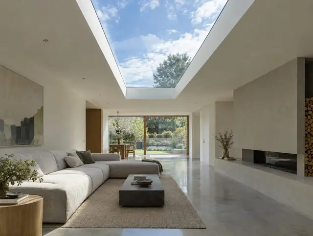 Long frameless structural glass rooflight over a minimalist living room